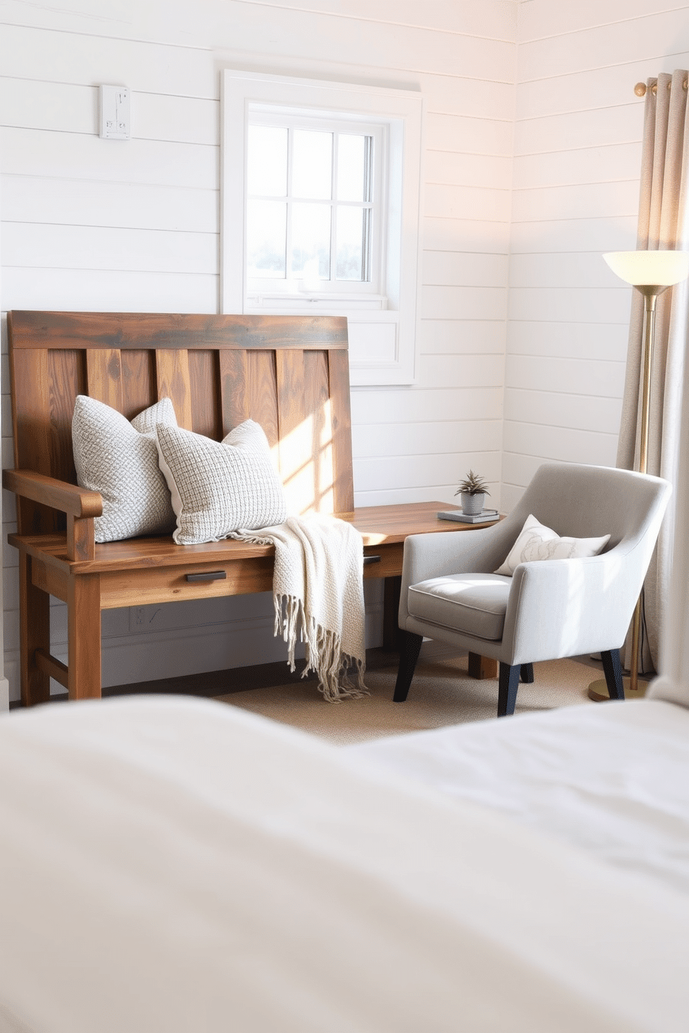 A rustic farmhouse-style bench crafted from reclaimed wood sits against a crisp white shiplap wall, radiating cozy charm. A woven throw blanket is draped over the bench, accompanied by a cluster of decorative pillows in neutral tones with subtle patterns. A serene bedroom reading nook is nestled by the window, bathed in soft natural light. It features a plush accent chair with a textured throw, a sleek side table holding a small potted plant, and a floor lamp with a warm, golden glow.