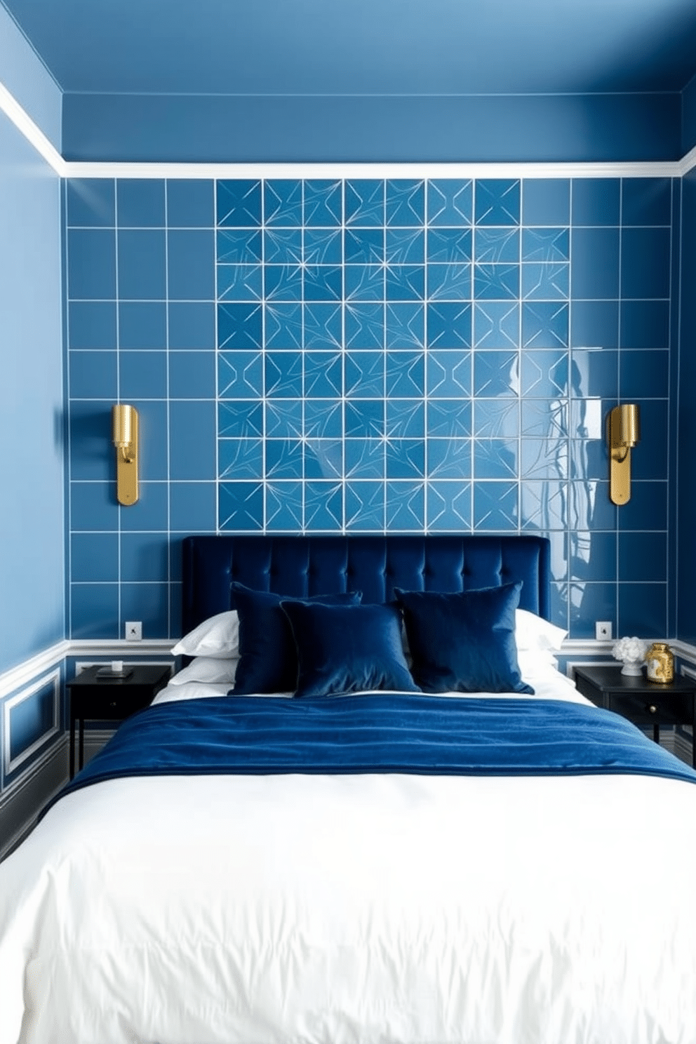 A modern blue bedroom with an accent wall featuring bold geometric blue tiles that create a striking focal point. The tiles form intricate patterns, complementing the surrounding muted blue walls and sleek white baseboards. A plush velvet bed in a deep navy hue is centered against the accent wall, paired with crisp white bedding and navy throw pillows. Gold sconces flank the bed, providing soft lighting that highlights the texture and depth of the tiled design.