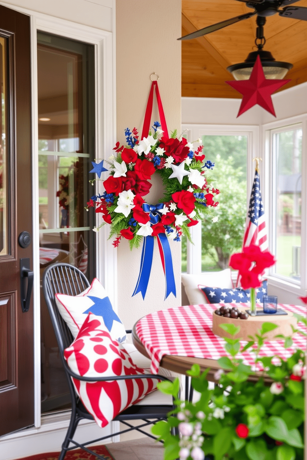 A festive Fourth of July themed wreath adorns the front door, featuring vibrant red, white, and blue flowers interspersed with stars and ribbons. The sunroom is decorated with patriotic accents, including throw pillows in star patterns and a table set with red and white checkered tablecloths for a cheerful Independence Day celebration.